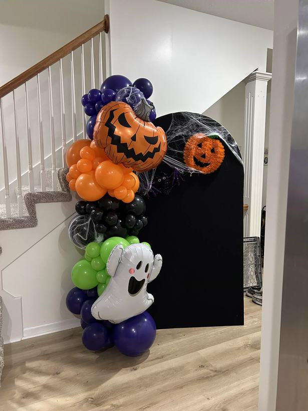 Halloween balloon garland in orange, purple and black with jack o lantern and ghost foils on a staircase