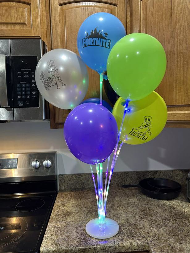 Themed birthday balloon bouquet centerpiece lit with LED lights, in green, blue, purple and silver